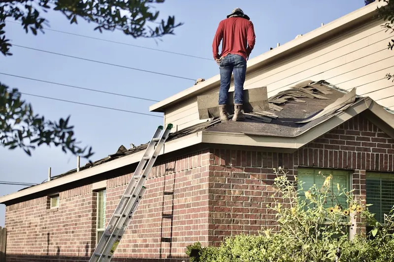 Professional roofer working on a residential roof in Hamilton Corner